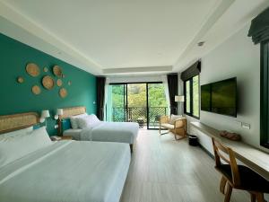 una camera d'albergo con due letti e una televisione di Keereen Resort - Ao Nang Krabi ad Aonang Beach