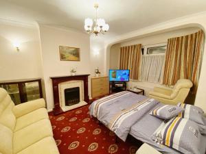 a bedroom with a bed and a fireplace and a television at Barking London House sleeps 12 - parking - train tube - airport in London