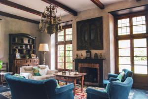 a living room with blue chairs and a fireplace at Relais Rantegosa - Holiday home in Chiavari