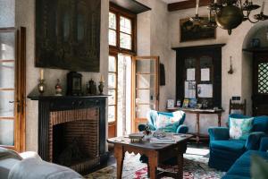 a living room with a fireplace and blue chairs at Relais Rantegosa - Holiday home in Chiavari