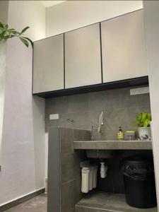 a kitchen with a sink and white cabinets at [New] Backlane Elegance 5pax Near Jonker 800m in Melaka