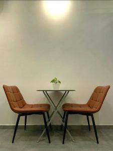 two chairs and a table with a plant on it at [New] Backlane Elegance 5pax Near Jonker 800m in Melaka