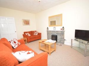 a living room with a orange couch and a fireplace at 2 Bed in Bideford 37262 in Bideford