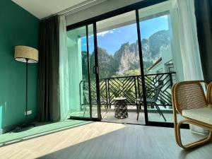 a room with a balcony with a view of the mountains at Keereen Resort - Ao Nang Krabi in Ao Nang Beach