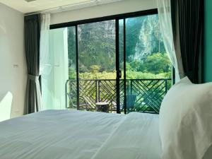 - une chambre avec un lit et une grande fenêtre dans l'établissement Keereen Resort - Ao Nang Krabi, à Ao Nang Beach