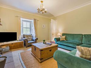 a living room with a couch and a tv at 3 Bed in Kirriemuir 37440 in Kirriemuir