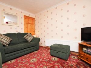 a living room with a green couch and a television at 1 bed property in Wadebridge Cornwall 42756 in Wadebridge