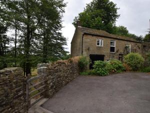 an old stone house with a fence in front of it at 2 Bed in Chapel-en-le-Frith PK606 in Chapel en le Frith