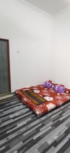 ein Bett auf dem Boden in einem Zimmer in der Unterkunft Homestay D'kolam in Pendang