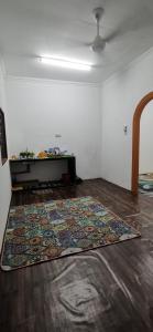 - un salon avec un tapis à l'étage dans l'établissement Homestay D'kolam, à Pendang