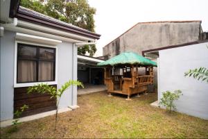 ein Haus mit einer Veranda mit einem grünen Sonnenschirm in der Unterkunft 3bd Lux City Oasis Las Pinas in Manila