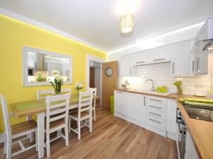 a kitchen with yellow walls and a wooden table and chairs at 3 Bed in Brixham BX078 in Brixham