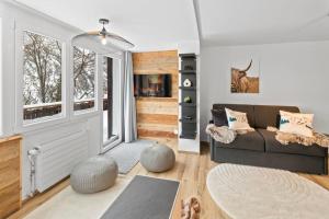 a living room with a couch and a window at Appartement rénové avec sauna privé in Saas-Fee