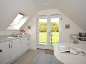 una cucina bianca con lavandino e finestra di 1 Bed in Narberth 46737 a Begelly