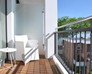 balkon ze stołem i krzesłem w obiekcie SeeHuus Lifestyle Hotel w mieście Timmendorfer Strand