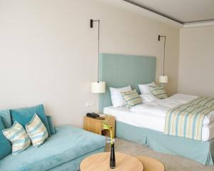 a living room with two beds and a couch at SeeHuus Lifestyle Hotel in Timmendorfer Strand
