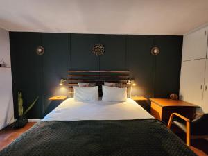 1 dormitorio con 1 cama grande y pared verde en Durbanville Pool House, en Durbanville