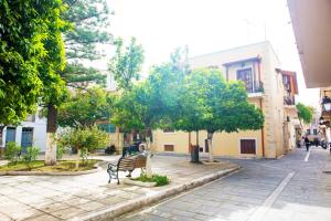 a park with a bench and trees and buildings at Mat Old Town Apartments L in Rethymno