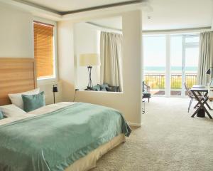 a bedroom with a bed and a view of the ocean at SeeHuus Lifestyle Hotel in Timmendorfer Strand