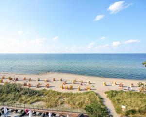 a beach with a bunch of umbrellas and the ocean at SeeHuus Lifestyle Hotel in Timmendorfer Strand