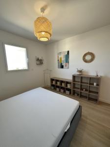 Un dormitorio con una gran cama blanca y una ventana. en Bel appartement neuf vue mer, en LʼÎle-Rousse