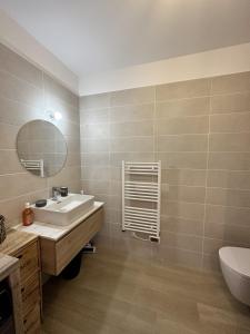 Un baño con lavabo, espejo e inodoro. en Bel appartement neuf vue mer, en LʼÎle-Rousse