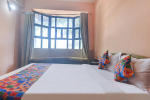 1 dormitorio con 1 cama grande y ventana en FabEscape Aqualura Verem With Swimming Pool en Nerul