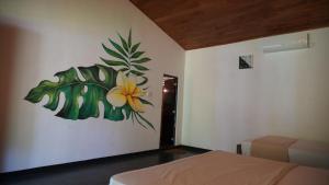 1 dormitorio con una pintura de una flor en la pared en Jayanti's en Sigiriya