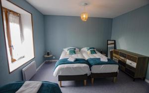 niebieska sypialnia z łóżkiem i komodą w obiekcie Le gite du chateau 1 