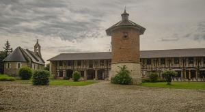 a large brick building with a tower in front of it at Le gite du chateau 1 