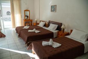 two beds in a hotel room with towels on them at Pagona Hotel in Loutra Edipsou
