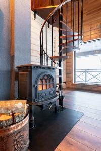 a wood stove in a room with a staircase at Holiday House "Brūklenes" in Talsi