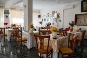 ルトラ・エディプソスにあるPagona Hotelの花のテーブルと椅子が並ぶレストラン