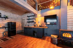 a kitchen with a bar and a fireplace in a cabin at Holiday House "Brūklenes" in Talsi