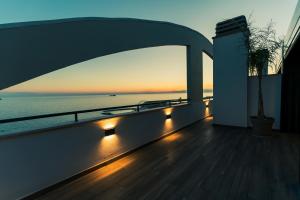 un balcón con vistas al océano al atardecer en Be Your Home - Tower Beach Suite en Civitavecchia