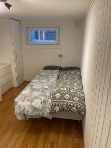 a bed in a small bedroom with a window at Leilighet med veldig sentral beliggenhet in Geilo