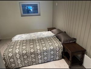 a bedroom with a bed and a table and a window at Leilighet med veldig sentral beliggenhet in Geilo