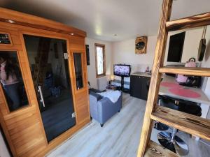 a living room with a staircase and a room with a desk at La cabane de rose in Fresse-sur-Moselle