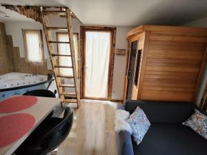 a room with a bed and a ladder and a couch at La cabane de rose in Fresse-sur-Moselle