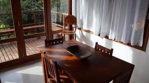a wooden table and chairs in a room with a window at Casa Terravista Trancoso in Trancoso