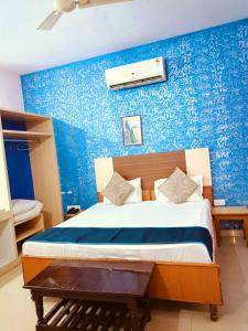 1 dormitorio con 1 cama con pared azul en Hotel Braj Haveli, en Jaipur