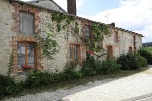 una vieja casa de ladrillo con hiedra creciendo en ella en Saint-malachie en Longchamp-sur-Aujon