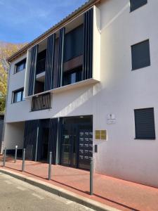 un bâtiment blanc avec une porte dans une rue dans l'établissement Appartement design au cœur de Montpellier avec parking privé, à Montpellier