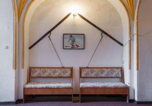 two benches in a room with a picture on the wall at Aki Apartment in Braşov