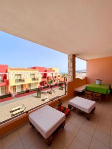 Un balcón con 2 camas y una mesa verde. en PORT DO SOL-free wi-fi no limits, en Sal Rei