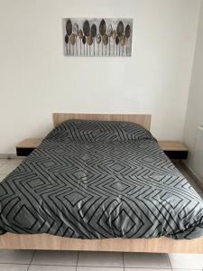 1 cama con edredón blanco y negro en una habitación en Très bel appartement entre Paris et Disneyland, en Lognes