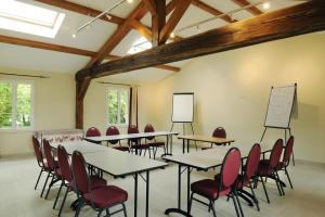 ein Klassenzimmer mit Tischen und Stühlen in einem Raum in der Unterkunft Le petit pre des marguerites in Rosnay-lʼHôpital