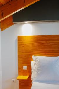 Casa Luís de Camões - Boutique & Literary House في Santar: غرفة نوم مع سرير مع اللوح الأمامي الخشبي