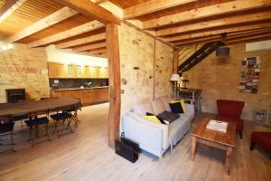 ein Wohnzimmer mit einem weißen Sofa und einem Tisch in der Unterkunft Maison de village proche Dordogne in Lacapelle-Biron