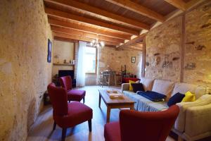 ein Wohnzimmer mit einem weißen Sofa und roten Stühlen in der Unterkunft Maison de village proche Dordogne in Lacapelle-Biron